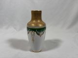 a white and gold vase with a green design on it