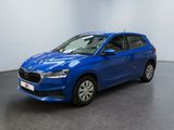une voiture bleue garée dans une pièce aux murs blancs
