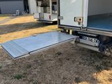 un camion blanc équipé d'une rampe à l'arrière