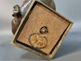 bronze figurine of a mouse with a wooden box on its back