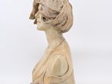 an image of a wooden busturine of a woman with a bird on her head