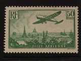 un timbre représentant un avion survolant une ville
