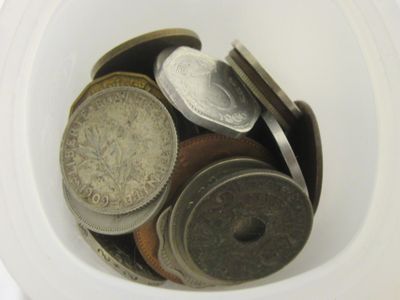 a white cup filled with coins sitting on top of a table