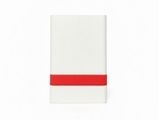 une serviette blanche ornée d'une bande rouge, posée sur une surface blanche