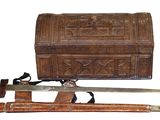 a wooden chest with a knife and a sword on it