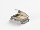 an image of a small silver box sitting on top of a white surface