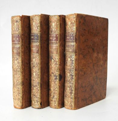 trois vieux livres posés l'un sur l'autre sur une surface blanche