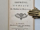 un livre ouvert posé sur une table, à côté d'une statue en or