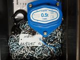 une étiquette bleue et blanche attachée à une chaîne dans une cabine téléphonique