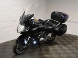a black motorcycle parked in a room with a checkered floor
