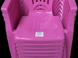 chaise en plastique rose sur fond noir, avec un fond noir