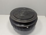 a black bowl with a lid on a white table