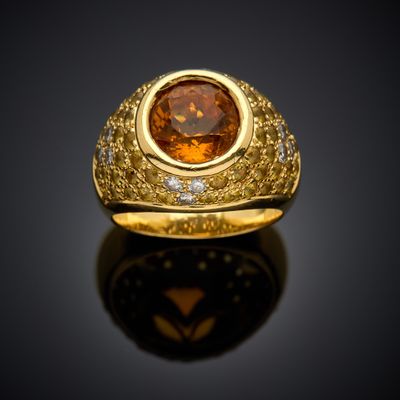 a close up of a gold ring with a large brown stone