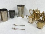 many different types of silverware on a white table