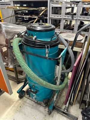 un aspirateur bleu posé au milieu d'une pièce