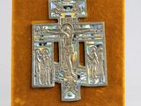 une image représentant une croix en argent sur laquelle figure Jésus, posée sur une surface en velours
