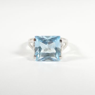 une photo d'une bague en topaze bleue sertie d'un diamant au centre