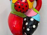une statue représentant une femme tenant un vase, posée sur un socle noir