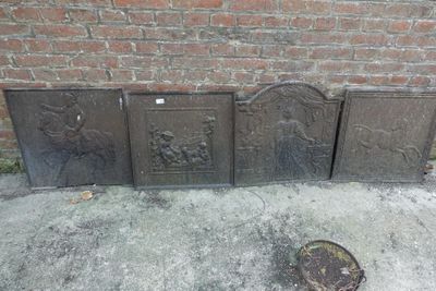 trois foyers en fonte posés sur un trottoir, à côté d'un mur de briques