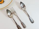 two spoons and a plate with a fish design on it