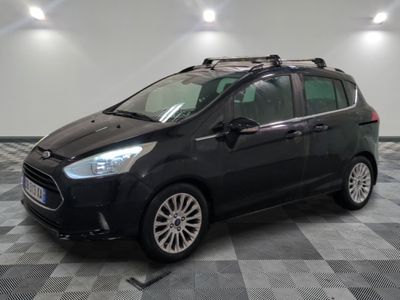 La voiture noire est garée sur le sol à damier du garage.