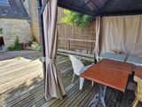 a patio with a table and chairs and a gazebo