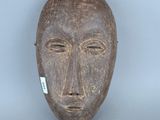 une image représentant un masque en bois sur lequel est accrochée une étiquette