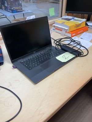 un ordinateur portable posé sur un bureau, devant un écran d'ordinateur