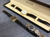 deux montres sont posées dans une boîte sur une surface bleue