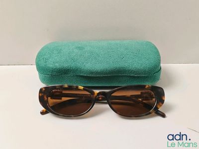 a close up of a pair of sunglasses with a green case