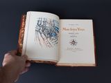 une personne tenant un livre ouvert sur une table