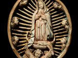 an image of a statue of the virgin of guadalupe surrounded by skulls