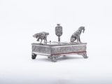 une figurine en argent représentant deux chevaux, posée sur une table