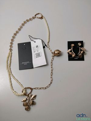 a close up of a necklace and earrings on a table