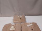 trois sacs remplis de couvertures marron posés sur une table blanche