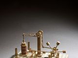 une image représentant une maquette miniature d'une machine à vapeur posée sur un damier