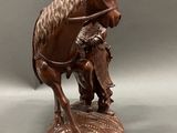 bronze statue of a man on a horse with a bird on its back