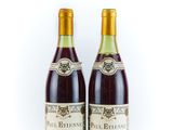 two bottles of wine sitting next to each other on a white surface