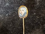 une image représentant un bâton en or sur lequel figure le portrait d'une femme