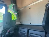 a seat in the back of a truck with a safety vest on