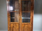 une vieille armoire en bois avec des portes vitrées dans une pièce