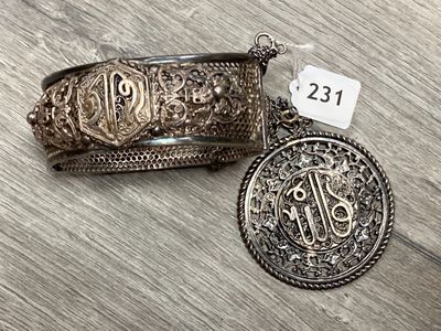 un gros plan sur un bracelet et une pièce de monnaie posés sur une table