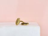 une bague en or posée sur un bloc blanc