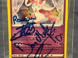 a close up of a pokemon card with a signed card