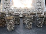 many silver cups sitting on a table next to a picture frame