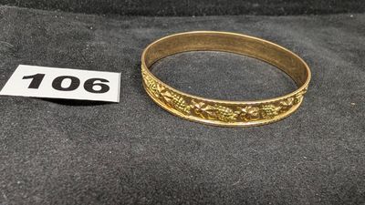 un gros plan d'une bague en or posée sur un tissu noir
