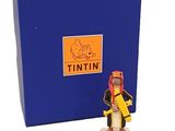 une petite figurine représentant un homme coiffé d'un chapeau