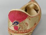 an old pair of shoes with a pink and gold design on them