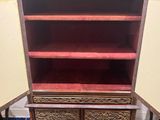 a wooden bookcase with red shelves in a room