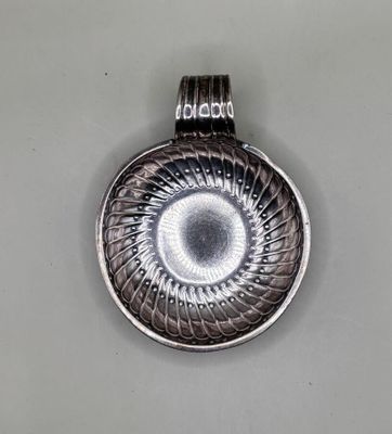 silver plated pendant with a spiral design on the front of it